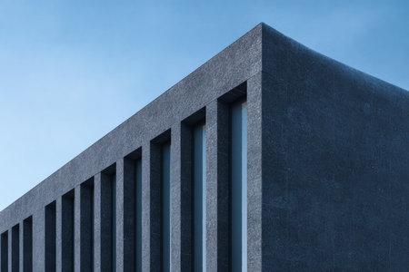 A close-up view of a modern building with sharp lines and textured surfaces against a clear blue sky. The distinct design emphasizes minimalism and elegance.の素材