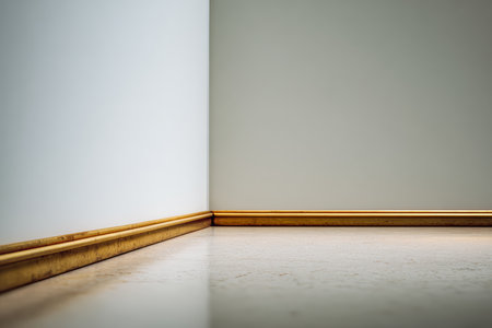 A quiet corner showcases smooth flooring and a wooden baseboard against a simple wall. Soft light highlights the clean lines, creating a serene atmosphere perfect for relaxation.の素材