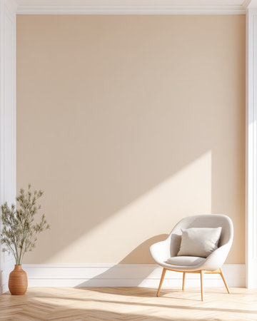 A light-colored room shows a soft chair beside a simple plant in a pot. Sunlight casts shadows on the wall. The space feels open and inviting.の素材