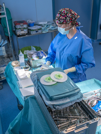 Surgeon waiting to start the operation. She has the table with all the surgical material ready.の写真素材