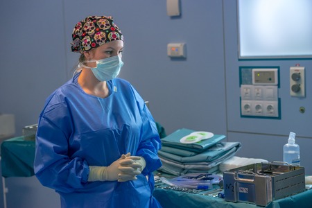 Surgeon waiting to start the operation. She has the table with all the surgical material ready.の写真素材
