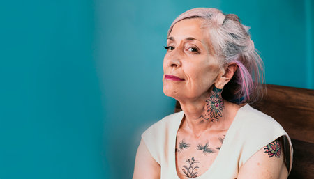 Offbeat close-up portrait of an elderly woman of unusual style. Elderly female person with colored personality. Tattooed senior citizen. Confident beautiful old woman.の素材