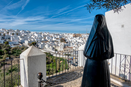 Statue of La Cobijada, monument to the woman, and in the background view of Vejer de la Frontera, a picturesque white village in the province of Cadiz, in the community of Andalusia, southern Spain.の写真素材