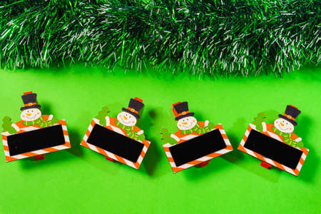 green christmas background with bell, candle, gift box, little snow manの写真素材