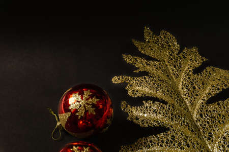 black christmas background with golden flower, golden berries, gift box and christmas ballsの写真素材