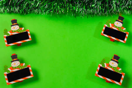 green christmas background with bell, candle, gift box, little snow manの写真素材