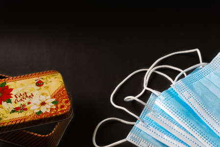 black christmas background with golden flower, golden berries, gift box and christmas ballsの写真素材