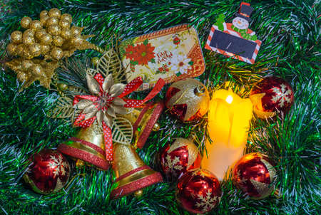 green christmas background with bell, candle, gift box, little snow manの写真素材