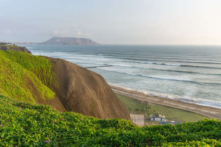 View of the ocean from the Miraflores District Peru, a cliff, tree and green grassの写真素材
