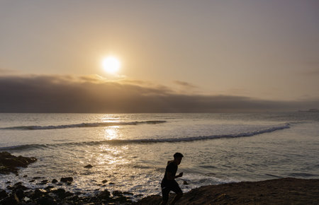 Sunset Landscape in the shore of Lima Peru, man runningの写真素材