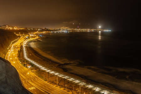 Night view of the ocean in Lima Peru, yellow lights in the highway, shore, long expositionの写真素材