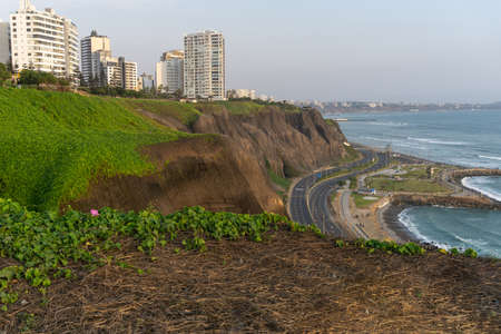 Ocean view from Miraflores Lima Peru, buildings in a cliff with grass, shoreの写真素材