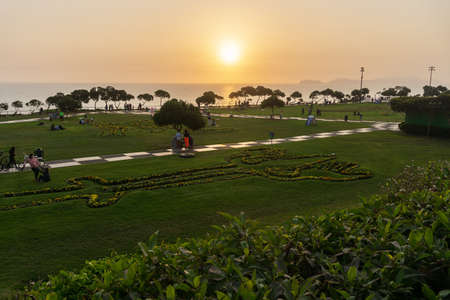 Sunset Landscape in the shore of Lima Peru, view from a park with grass and a treeの写真素材