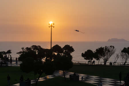 Sunset Landscape in the shore of Lima Peru, view from a park with grass and a treeの写真素材