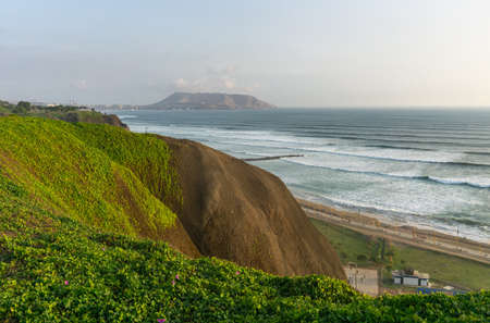 View of the ocean from the Miraflores District Peru, a cliff, tree and green grassの写真素材
