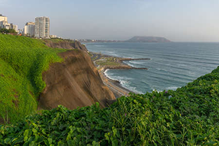Ocean view from Miraflores Lima Peru, buildings in a cliff with grass, shoreの写真素材