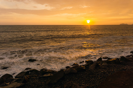 Beautiful sunset in Lima Peru, bright sky and underexposed beach, golden hour, orange skyの写真素材