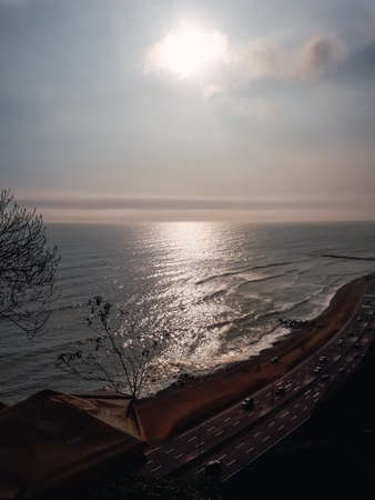 Beautiful sunset landscape in the coast of Lima Peru, Miraflores Distric. Car in a highway, Underexposedの写真素材