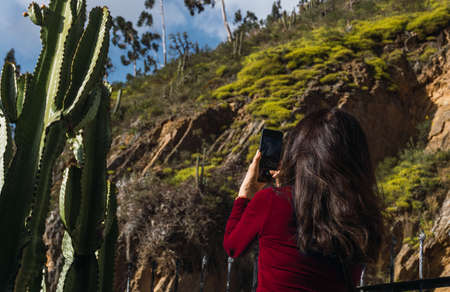 unrecognizable woman in red t-shirt taking photos of a mountain in Acobamba, Tarma, Peru.の写真素材
