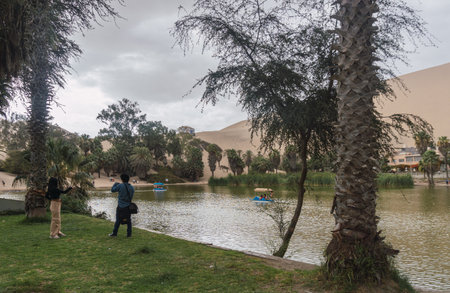 Couple of friends hanging out at huacachina lagoonの写真素材