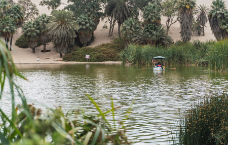 people taking a boat ride in the huacachina lagoon ica peruの写真素材