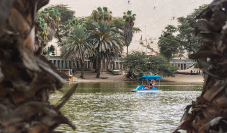 people taking a boat ride in the huacachina lagoon ica peruの写真素材