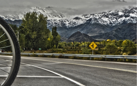Beautiful mountain landscape, where you can see the imposing Andes Mountains with snowy peaks, on a cloudy day, with the green landscape of southern Mendoza, Argentina, an area with its charms for bike rides, through the vineyards and tourism wineries calの写真素材