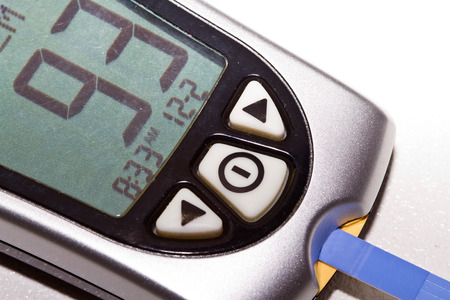 A blood glucose meter showing normal blood sugar resultsの写真素材