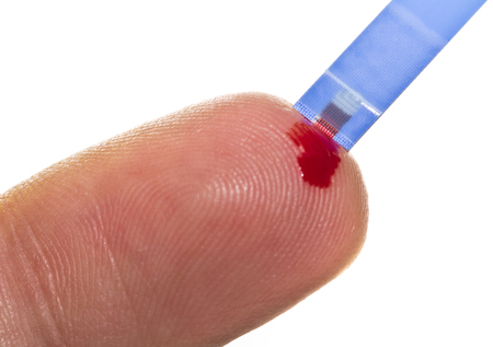 Checking the glucose level with a drop of bloodの写真素材
