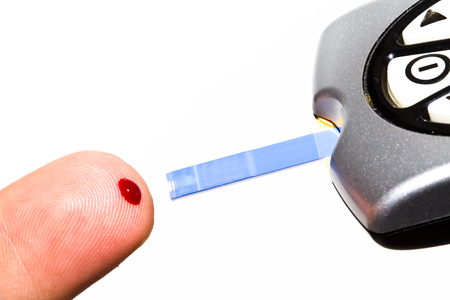 Checking the glucose level with a glucometerの写真素材