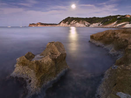 Beautiful seascape showing the moonlight reflected on the water. Long time of exposure used to create a silky effect on the waterの写真素材