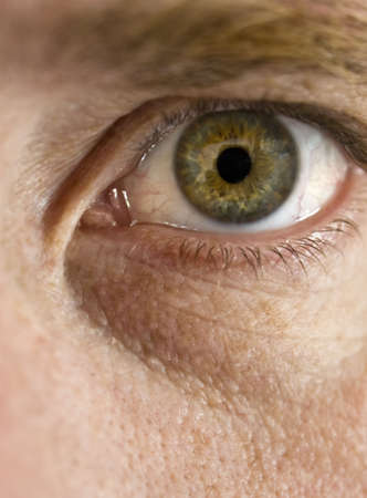 Close up view of a man's green eye looking at camera の写真素材
