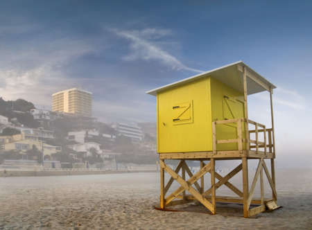 Beach scene taken in Benidorm, Costa Blanca, Spain, in a foggy day, with a yellow lifeguard stand on the foregroungの写真素材