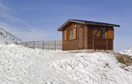 Small wooden house on a snowy mountain の写真素材