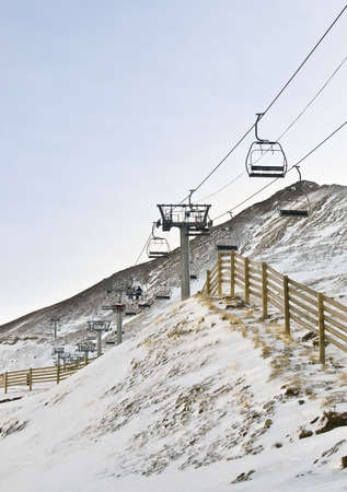 Snowy landscape in a ski resort, with the cable cars climb to the summit の写真素材