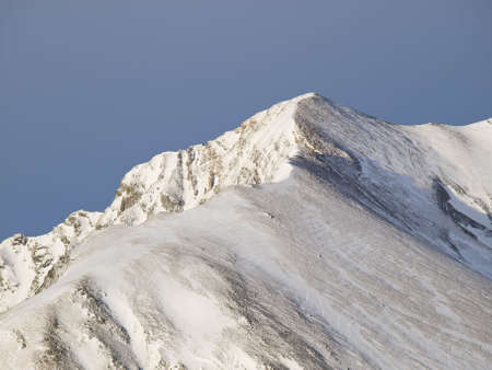 Isolated peak of a mountain covered with snowの写真素材