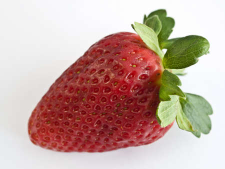 Delicious strawberry with its green leaves isolated on a white backgroundの写真素材