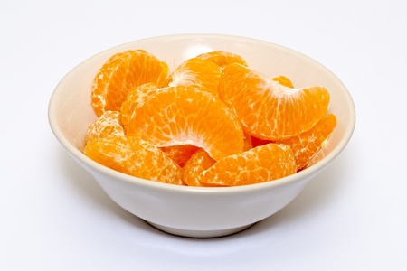 peeled mandarin orange in a bowl on white backgroundの写真素材