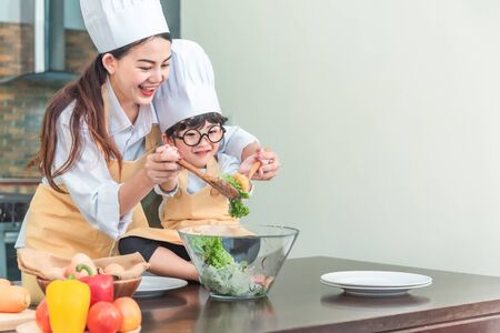 Happy family in the kitchen. mother and child daughter preparing the dough, saladの写真素材