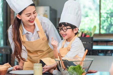 Young Mother and daughter cooking meal togetherの写真素材