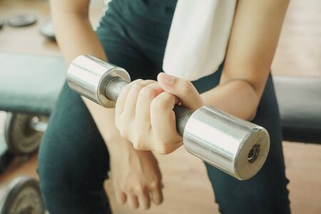 Bodybuilder working out with dumbbell weights at the gym.man bodybuilder doing exercises with dumbbell. Fitness muscular bodyの写真素材