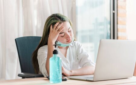 Coronavirus. Business woman working from home wearing protective mask. Business woman in quarantine for coronavirus wearing protective mask.の写真素材