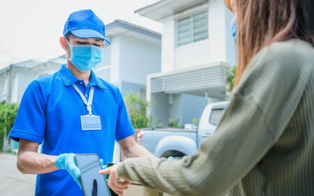 Woman receiving package from delivery manの写真素材