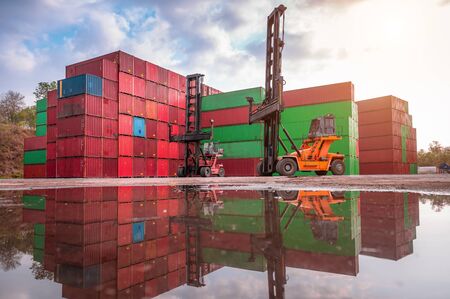 Forklift truck handling cargo shipping container box in logistic shipping yard with cargo container stack in background
の写真素材