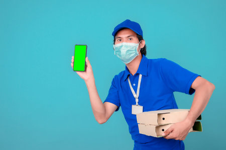 Delivery service man holding cardboard boxes on blue background copy spaceの写真素材
