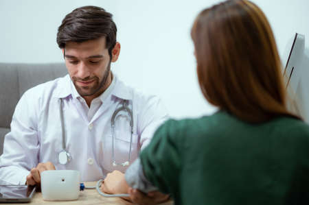The doctor is checking the pressure of a young patient before undergoing cosmetic surgery.の写真素材