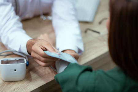 The doctor is checking the pressure of a young patient before undergoing cosmetic surgery.の写真素材