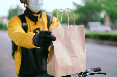 Anonymous fast delivery food service at home. Man courier delivered the order bag  with food.の写真素材