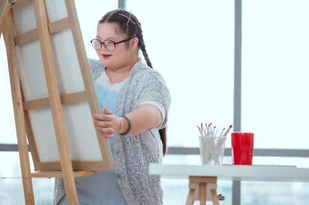Down syndrome drawing a picture on the floor at homeの写真素材