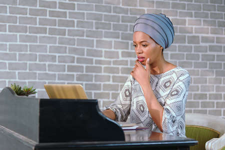 Young Afro Business Lady Smiling Sitting In Modern Homeの写真素材